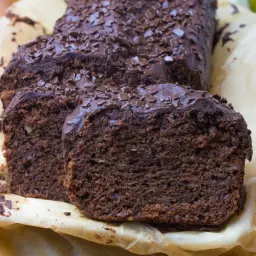 Proste ciasto bananowe z olejem i kakao, oblane czekoladą i posypane wiórkami. Idealne na deser.