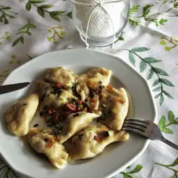 Pyszne pierogi, które przypominają o tym, skąd pochodzą – z serca polskiej tradycji kulinarnej. Podane z okrasą i szczypiorkiem.