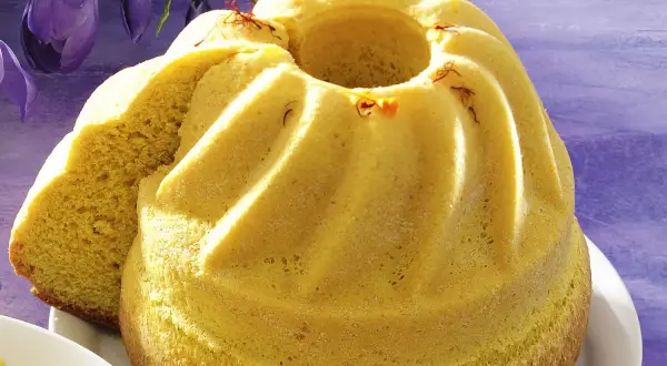 Żółty, puszysty babka wielkanocna, ozdobiona szafranem, wygląda jak bardzo stare ciasto wielkanocne.