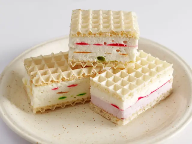 Przepis na wafle z galaretką i śmietaną: słodkie kwadraty z kolorowymi akcentami, idealne na deser.